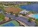 View of neighborhood amenities: clubhouse, pool, tennis courts, parking, and a large open field at 1760 Fox Grape Loop, Lutz, FL 33558
