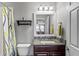 Cozy bathroom with granite vanity, modern fixtures, and decorative mirror; features a shower-tub combo at 1760 Fox Grape Loop, Lutz, FL 33558
