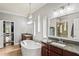 Spacious bathroom featuring double sink vanity, large bathtub, and access to walk-in closet and glass shower at 1760 Fox Grape Loop, Lutz, FL 33558