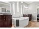 Bathroom featuring double sinks, a luxurious soaking tub, and tile flooring at 1760 Fox Grape Loop, Lutz, FL 33558