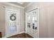 Inviting foyer with hardwood floors, decorative glass door, and French doors that lead to a study/office at 1760 Fox Grape Loop, Lutz, FL 33558