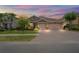 Beautiful home exterior at sunset with a well-maintained lawn, charming landscaping, and a spacious driveway at 1760 Fox Grape Loop, Lutz, FL 33558