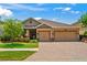 Charming home featuring a well-manicured lawn, brick driveway, and a two-car garage, perfect for suburban living at 1760 Fox Grape Loop, Lutz, FL 33558