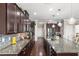 Gourmet kitchen with dark wood cabinets, granite countertops, and stainless steel appliances at 1760 Fox Grape Loop, Lutz, FL 33558