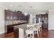 Open kitchen with an island, granite countertops, dark cabinets, and pendant lighting at 1760 Fox Grape Loop, Lutz, FL 33558