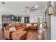 Spacious living room featuring a large brown sectional, ceiling fan, and hardwood flooring at 1760 Fox Grape Loop, Lutz, FL 33558