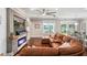 Living room with a brown sectional sofa, electric fireplace, and scenic backyard views at 1760 Fox Grape Loop, Lutz, FL 33558
