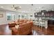 Open-concept living space with a large sectional sofa, modern kitchen, and beautiful views of the backyard at 1760 Fox Grape Loop, Lutz, FL 33558