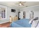 Charming main bedroom featuring wood floors, a ceiling fan, a dresser, and access to a walk-in closet at 1760 Fox Grape Loop, Lutz, FL 33558