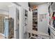 Large walk-in closet featuring custom shelves, drawers, hanging racks, and a built-in ironing board at 1760 Fox Grape Loop, Lutz, FL 33558