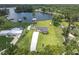 Scenic aerial view of waterfront home, lush greenery and dock on a sunny day at 18102 Spencer Rd, Odessa, FL 33556
