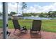 Inviting backyard patio featuring serene lake views and two comfortable outdoor chairs at 18102 Spencer Rd, Odessa, FL 33556