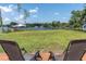 Inviting backyard patio featuring serene lake views and two comfortable outdoor chairs at 18102 Spencer Rd, Odessa, FL 33556