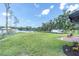 Expansive backyard featuring lake access, lush lawn, and charming patio area at 18102 Spencer Rd, Odessa, FL 33556