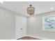 Bedroom with neutral paint, modern flooring, and wooden beaded chandelier at 18102 Spencer Rd, Odessa, FL 33556