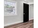 Bedroom featuring a window and dark paneled door that lets in natural light at 18102 Spencer Rd, Odessa, FL 33556