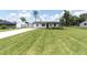 Well-manicured lawn complements this charming home with an expansive driveway at 18102 Spencer Rd, Odessa, FL 33556