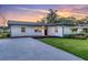 Beautiful single story home at sunset with manicured lawn and spacious driveway at 18102 Spencer Rd, Odessa, FL 33556