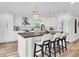 Bright, spacious kitchen boasts white cabinets, a large island with seating, and elegant pendant lighting fixtures at 18102 Spencer Rd, Odessa, FL 33556