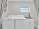 Neat laundry room with window, stacked washer and dryer, and stainless steel sink at 18102 Spencer Rd, Odessa, FL 33556