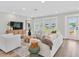 Bright living room boasts ample seating and serene lake views through French doors at 18102 Spencer Rd, Odessa, FL 33556