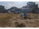 Spacious fenced backyard features screened patio and fire pit with chairs at 2004 Culberson Ave, Dunedin, FL 34698