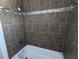 Tiled bathtub and shower with decorative blue mosaic tiling at 2004 Culberson Ave, Dunedin, FL 34698