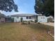 Inviting light blue single-story home featuring a well-maintained lawn and beautifully arranged front garden at 2004 Culberson Ave, Dunedin, FL 34698
