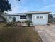 Charming single-story home with light blue siding, manicured front garden, and a cozy brick-paved seating area at 2004 Culberson Ave, Dunedin, FL 34698