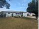 Beautiful light blue single-story house with a manicured lawn and a decorative flower bed in the front yard at 2004 Culberson Ave, Dunedin, FL 34698