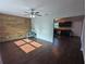 Bright living room featuring stylish wood panel wall, modern ceiling fan, and hardwood floors at 2004 Culberson Ave, Dunedin, FL 34698
