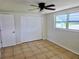 Bedroom with tile floors, ceiling fan, closet and natural light from a large window creating a cozy retreat at 2051 Peggy Dr, Holiday, FL 34690