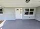 Charming front porch with a gray floor and white door at 2051 Peggy Dr, Holiday, FL 34690