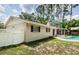 Backyard view showcasing a refreshing pool and screened-in lanai, framed by lush landscaping and a white picket fence at 22154 Weeks Blvd, Land O Lakes, FL 34639