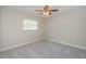 A simple bedroom with a neutral color scheme and a ceiling fan at 22154 Weeks Blvd, Land O Lakes, FL 34639