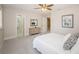 Neutral bedroom featuring a ceiling fan, soft carpet, a dresser, and art at 22154 Weeks Blvd, Land O Lakes, FL 34639
