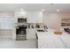 Modern kitchen with stainless steel appliances, marble countertops, and bright white cabinets and white marble floors at 22154 Weeks Blvd, Land O Lakes, FL 34639
