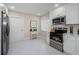 Bright kitchen features stainless steel appliances, white cabinets, and white marble floors at 22154 Weeks Blvd, Land O Lakes, FL 34639