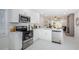 Updated kitchen features stainless steel appliances, white cabinets, marble floors, and an open floor plan at 22154 Weeks Blvd, Land O Lakes, FL 34639
