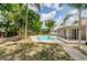 A tranquil pool nestled in a lush backyard oasis, featuring tropical trees and serene blue skies at 22154 Weeks Blvd, Land O Lakes, FL 34639