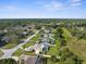 This aerial view shows houses in a tree-lined neighborhood featuring mature landscaping and private backyard pools at 2585 Waterfall Dr, Spring Hill, FL 34608