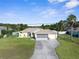 Well-kept single-story home featuring a manicured lawn, mature landscaping, and an attached two-car garage at 2585 Waterfall Dr, Spring Hill, FL 34608