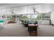 Bright sunroom with ceiling fans, neutral carpet, and wicker furniture overlooking serene outdoor views at 2585 Waterfall Dr, Spring Hill, FL 34608