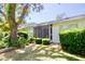 Well-manicured backyard featuring a screen-enclosed porch and lush landscaping at 2836 Featherstone # 2836, Holiday, FL 34691