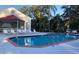 Community pool with lounge chairs and lush landscaping at 2836 Featherstone # 2836, Holiday, FL 34691