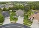 Overhead view of the home displaying a three-car garage, lush landscaping, and circular driveway at 3243 Stonegate Falls Dr, Land O Lakes, FL 34638