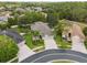 Overhead view of the home displaying a three-car garage, lush landscaping, and circular driveway at 3243 Stonegate Falls Dr, Land O Lakes, FL 34638
