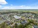 An aerial view shows the community homes surrounding the scenic lake at 3243 Stonegate Falls Dr, Land O Lakes, FL 34638