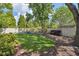 Relaxing backyard with manicured lawn, mature trees, fire pit, and blue Adirondack chairs at 3243 Stonegate Falls Dr, Land O Lakes, FL 34638