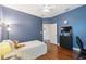 This bedroom has hardwood floors and is painted blue; a ceiling fan provides overhead lighting at 3243 Stonegate Falls Dr, Land O Lakes, FL 34638